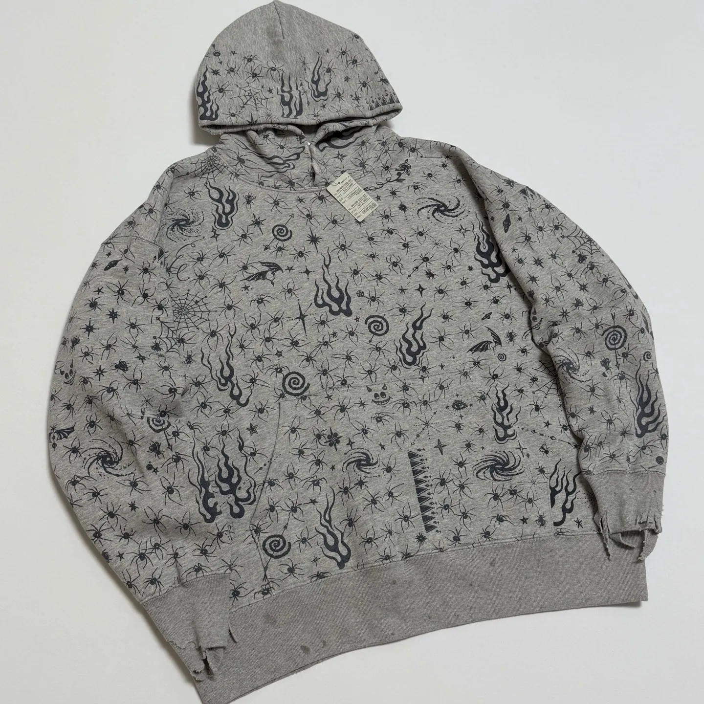SAINT Mxxxxxx x DR. WOO HOODIE ' Dr.Woo ' /GRY Flame Swirl Spider Web Hoodie Distressed Gray S-XL Custom-woven and dyed nostalgic gray fabric. After printing, the garment is sprayed with potion to cause the fabric to oxidize and fade. A large number of artificial fabric destruction processes are added to make the whole piece of clothing look aged and unique like a work of art. This hoodie is co-branded with a famous tattoo design artist and customized with a full set of Dr.Woo accessories. Bringing you authentic items!